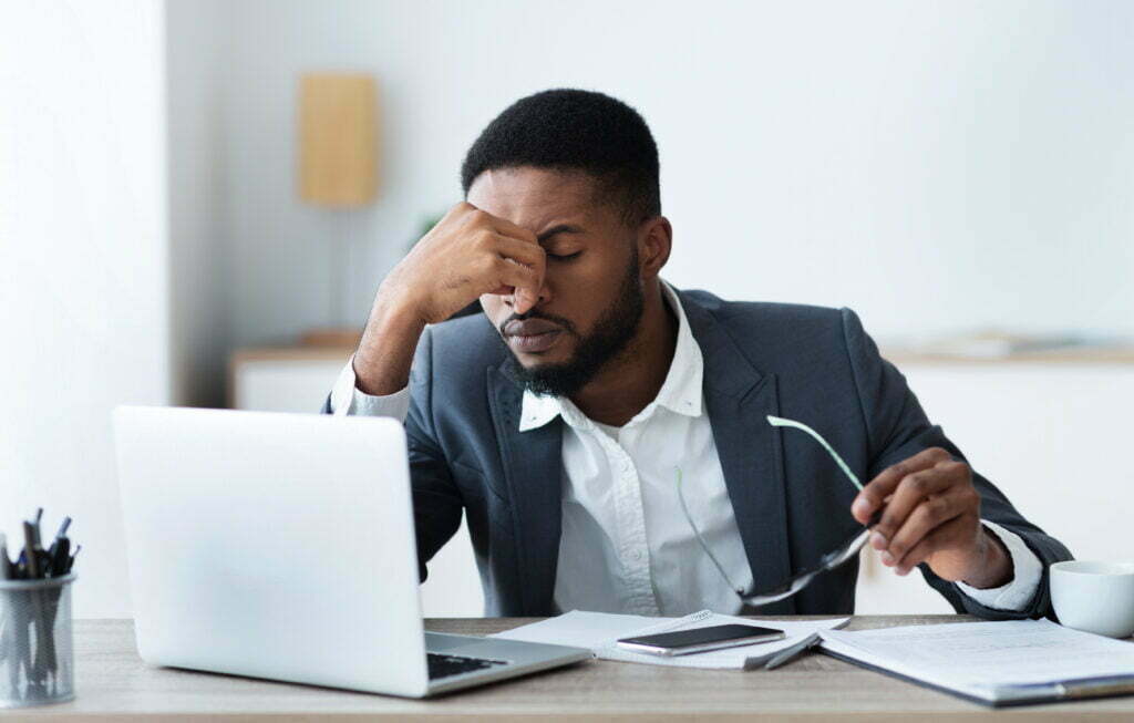 African american businessman tired of long time siting at work