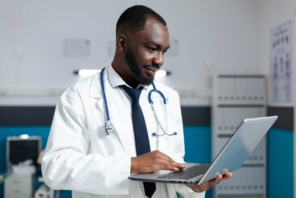 doctor using laptop for remote patient monitoring