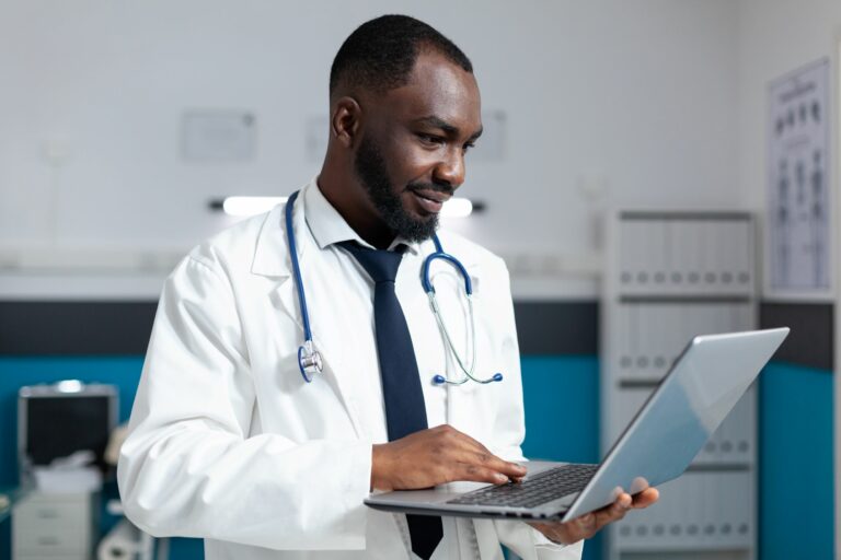 doctor using laptop for remote patient monitoring doctor using laptop for remote patient monitoring