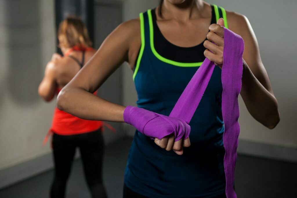 women tying hand wrap preparing for exercise