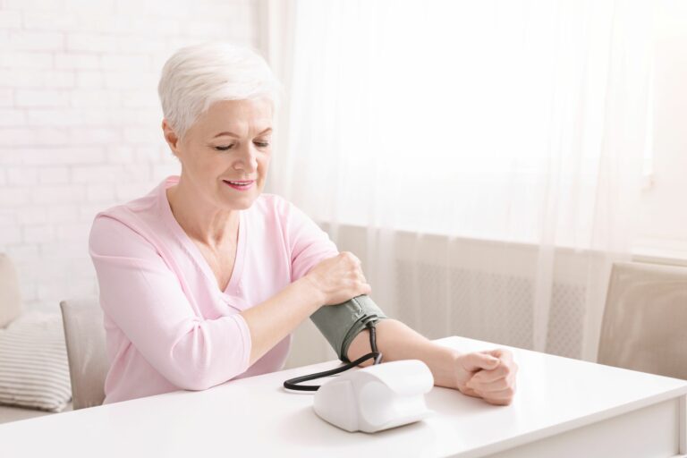 woman controlling high blood pressure using medical device monitoring