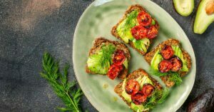 Avocado toast with roasted tomatoes in a plate