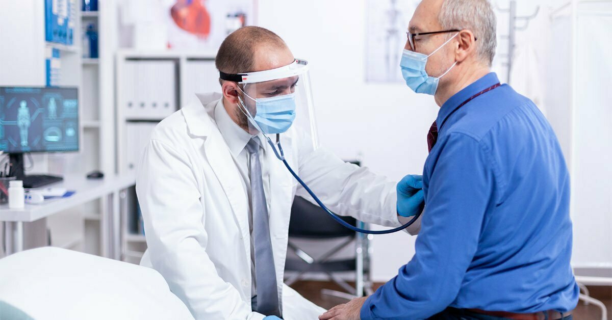 doctor using stethoscope to listen to man heart during covid consultation doctor using stethoscope to listen to man heart during covid consultation
