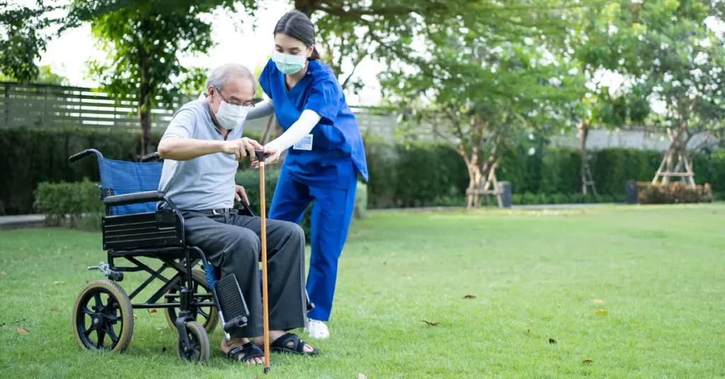 management of parkinson's disease caregiver supports patient in wheelchair using a cane