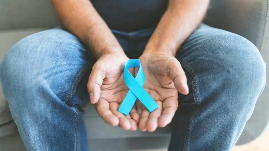 colon cancer awareness month man holding blue ribbon
