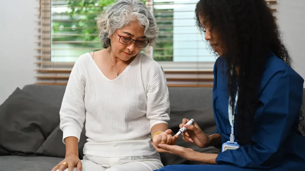 caregiver measuring patient glucose level for diabetes home care