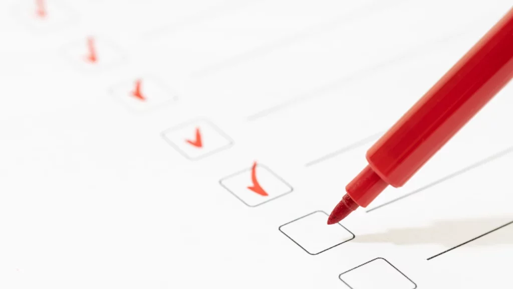 paper checklist with red marker for eligibility check